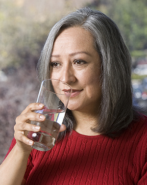 Mujer bebiendo un vaso de agua.